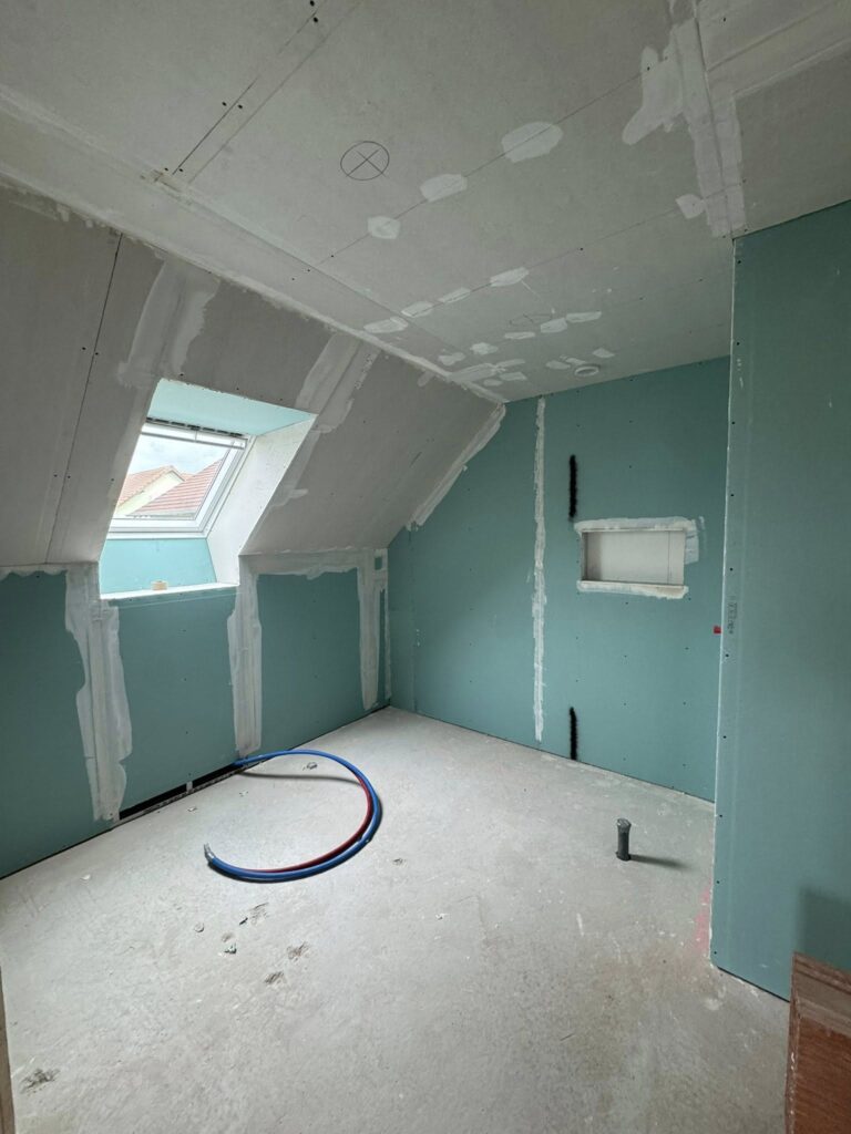 Plaquage et finitions en cours dans une future salle de bain pour une surface nette et prête à l’aménagement