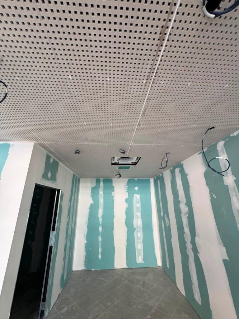 Plaques perforées de plafond acoustique installées en intérieur.