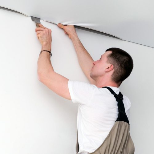 Installation d’un faux plafond tendu par un professionnel pour une finition lisse et moderne