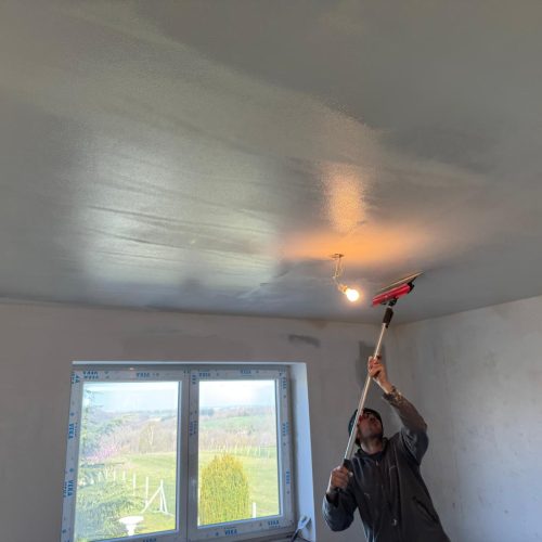 Lissage de l’enduit sur le plafond pour obtenir une surface plane et prête à peindre